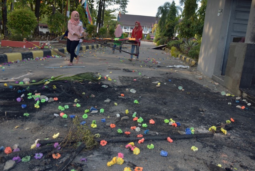 Sejumlah petugas kebersihan bersama pegawai Rektorat Universitas Riau membersihkan bekas bentrokan di area Gedung Fakultas Ilmu Sosial dan Politik Universitas Riau, di Kota Pekanbaru, Jumat (6/10).
