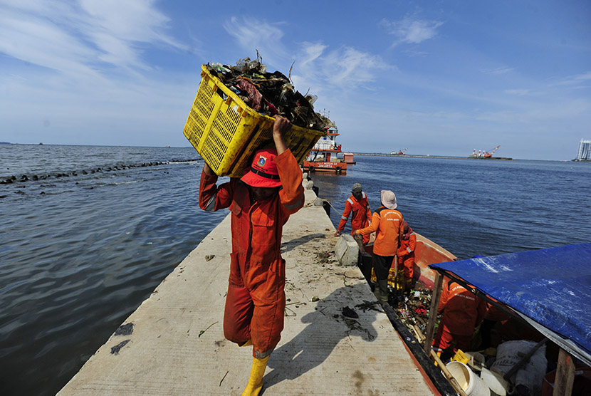 Sejumlah petugas kebersihan DKI Jakarta memindahkan sampah dari kapal yang diambil dari kawasan teluk Jakarta di Pelabuhan Muara Angke Jakarta, Senin (28/12).