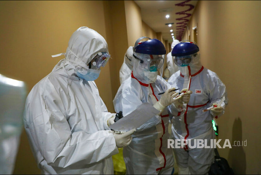 Sejumlah petugas kesehatan berpakaian pelindung memeriksa pasien di hotel yang digunakan sebagai tempat isolasi warga di Wuhan, Hubei, China, senin(3/2). 