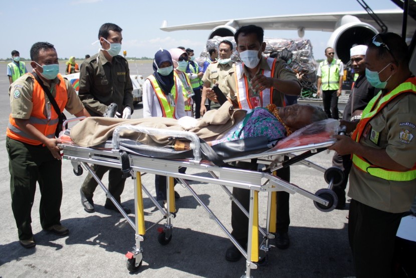 Sejumlah petugas medis membawa seorang jemaah haji yang mengalami sakit saat tiba di tanah air di Bandara Internasional Juanda Surabaya di Sidoarjo, Jawa Timur, Minggu (18/9). 