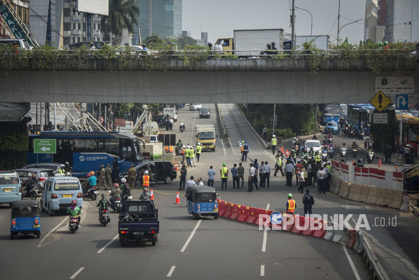 Sejumlah petugas melakukan pelaksanaan uji coba pengaturan dan rekayasa lalu lintas di simpang Matraman, Jakarta, Kamis (20/7).