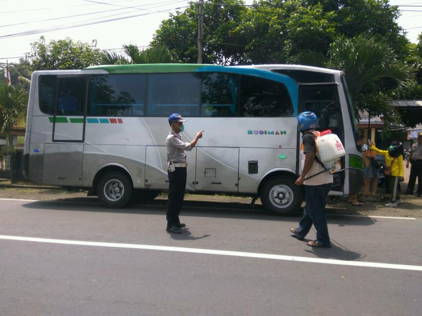 Sejumlah petugas melakukan penyemprotan disinfektan ke angkutan umum dan mengecek suhu tubuh penumpang yang datang dari luar kota, di Kecamatan Kalipucang, Kabupaten Pangandaran, Jumat (27/3).