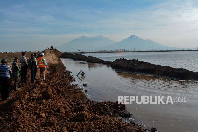 Sejumlah petugas melihat tanggul penahan lumpur Porong yang ambles di titik 67 Gempol Sari, Tanggulangin, Sidoarjo, Jawa Timur, Jumat (5/10).