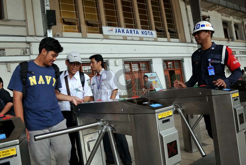 Petugas membantu calon penumpang kereta api listrik (KRL) menggunakan tiket elektronik (e-ticketing) di Stasiun Jakarta Kota, Selasa (23/4).    (Republika/Prayogi)
