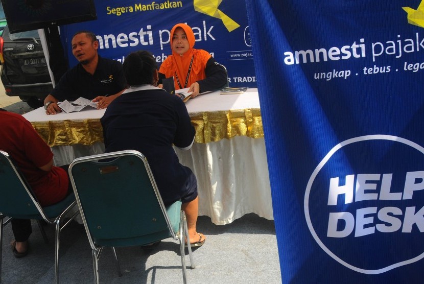 Sejumlah petugas memberikan sosialisasi Amnesti Pajak kepada pedagang di Pasar Sunggingan, Boyolali, Jawa Tengah, Senin (28/11). 