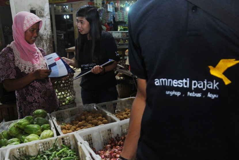 Sejumlah petugas memberikan sosialisasi Amnesti Pajak kepada pedagang di Pasar Sunggingan, Boyolali, Jawa Tengah, Senin (28/11).