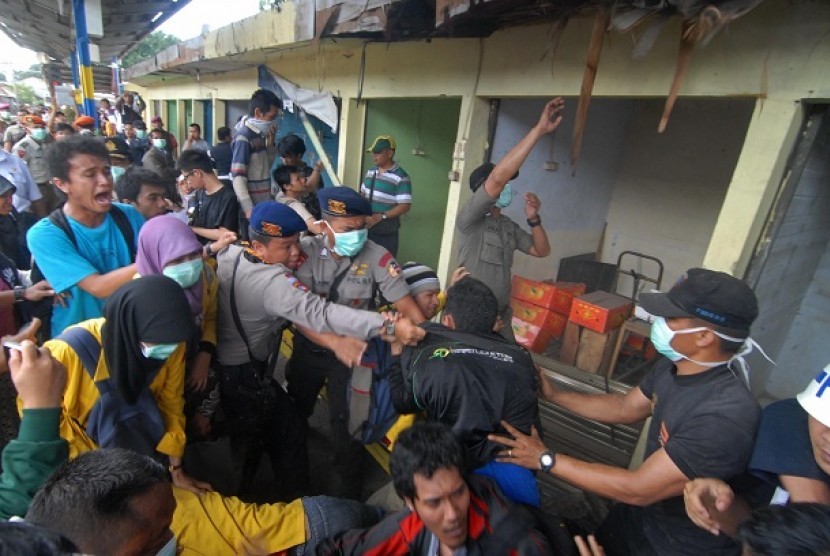 Sejumlah Petugas membongkar sejumlah kios pedagang kaki lima (PKL) di Stasiun Lenteng Agung, Jakarta Selatan, Ahad (30/12). Meskipun proses penertiban ini sempat ricuh karena sejumlah mahasiswa mengajak berdialog namun proses penertiban tetap dilakukan gun