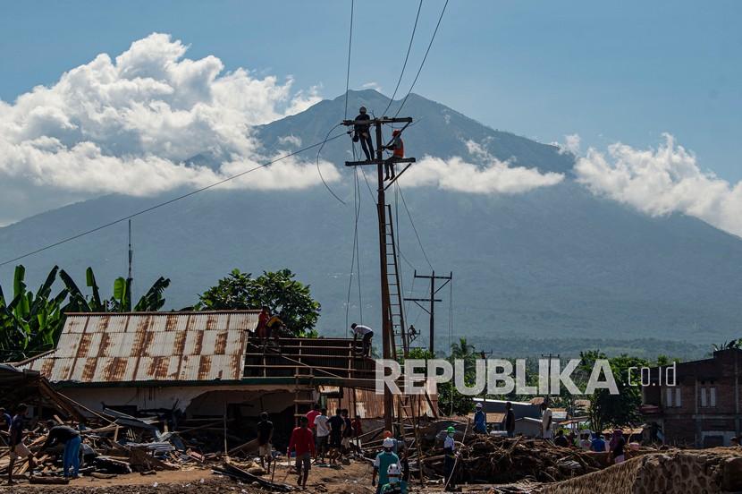 Sejumlah petugas memperbaiki jaringan listrik yang terputus akibat banjir bandang di Adonara Timur, Kabupaten Flores Timur, Nusa Tenggara Timur (NTT), Kamis (8/4/2021).