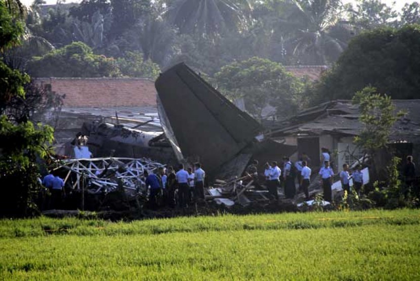 Sejumlah Petugas mengamankan bangkai pesawat Fokker 27 yang terjatuh di komplek Rajawali, Lapangan Udara Halim Perdana Kusuma, Jakarta, Kamis (21/6).