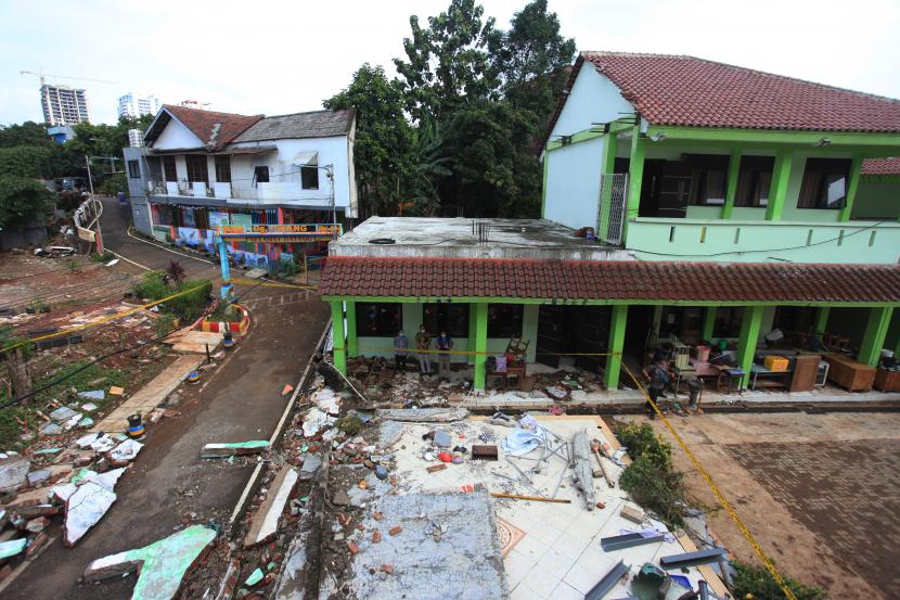 Sejumlah petugas mengamati tembok roboh akibat banjir di MTSN 19 Pondok Labu, Jakarta, Jumat (7/10/2022). Sebanyak tiga orang siswa di MTSN 19 Pondok Labu meninggal tertimpa tembok yang roboh akibat terjangan banjir pada sekolah tersebut pada Kamis (6/10) sore. Tragedi Tembok Roboh MTsN 19 Jakarta, KemenPPPA Dorong Perlindungan Anak