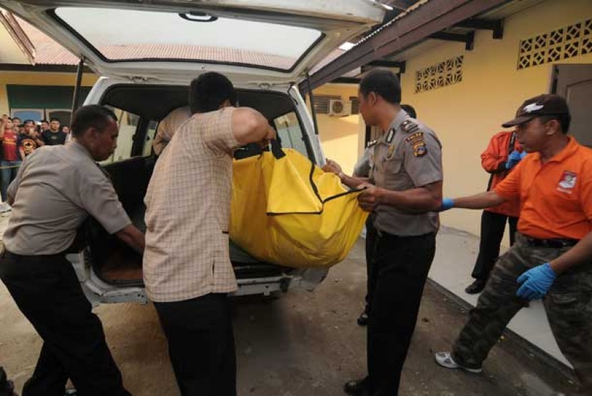  Sejumlah petugas mengangkat jenazah pelaku bom bunuh diri yang baru tiba di Rumah Sakit Bhayangkara Palu, Sulawesi Tengah, Senin (3/6).