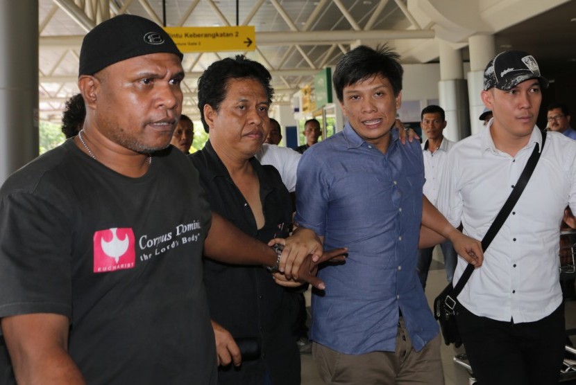 Sejumlah petugas mengawal Bupati Ogan Ilir (OI) Ahmad Wazir Nofiandi (kedua kanan) saat tiba di Bandara Sultan Mahmud Baddarudin (SMB) II Palembang, Sumatera Selatan, Senin (14/11).