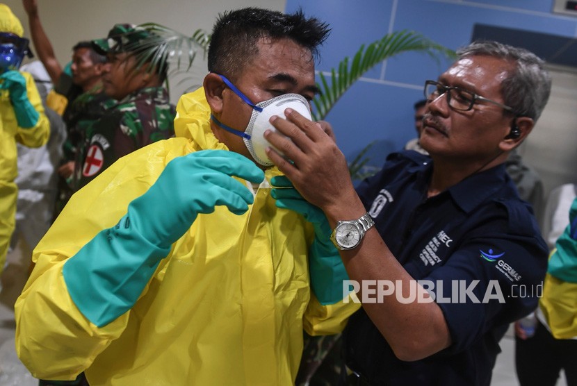 Sejumlah petugas mengenakan pakaian pelindung lengkap saat bersiap menyambut kedatangan kru kapal pesiar Diamond Princess yang dinyatakan negatif virus corona di Bandara Kertajati, Kabupaten Majalengka, Jawa Barat, Ahad (1/3/2020).