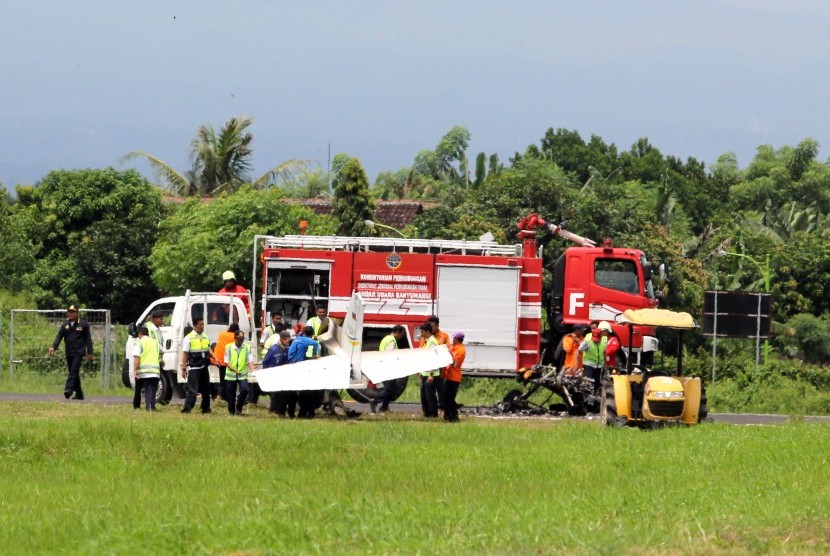 Sejumlah petugas mengevakuasi bangkai pesawat latih yang gagal landing di Bandara Blimbingsari, Banyuwangi, Jawa Timur, Senin (16/1). 