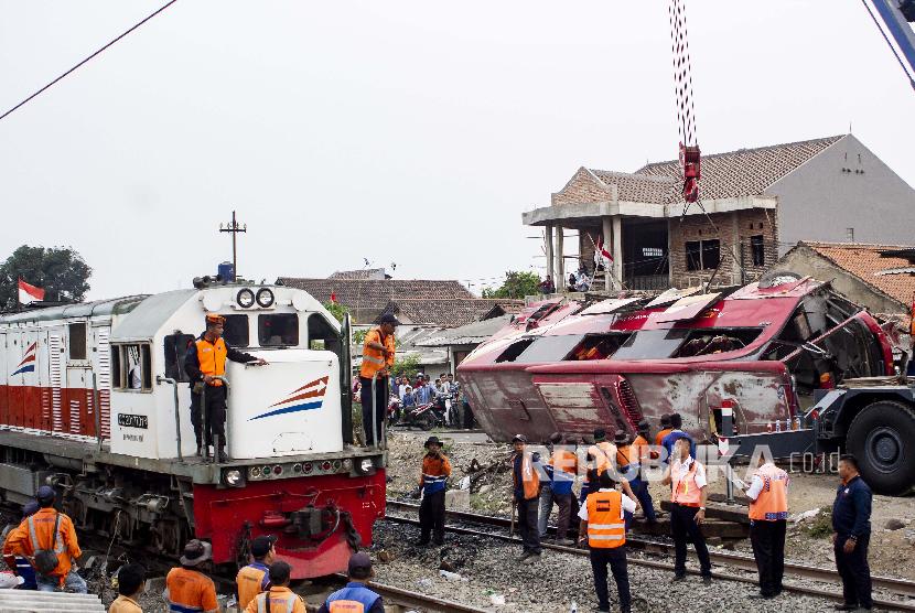 Sejumlah petugas mengevakuasi bus yang tertabrak kereta api Argo Parahyangan KA-32 jurusan Gambir - Bandung di Warung Bambu, Karawang, Jawa Barat, Senin (26/08/2019). Kecelakaan tersebut terjadi akibat bus dengan nomor polisi T 7915 DC mogok di tengah perlintasan kereta api. 