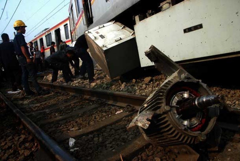   Sejumlah petugas mengevakuasi gerbong KRL Commuter Line Jurusan Bogor-Jakarta Kota yang anjlok dan menabrak pembatas rel di Stasiun Cilebut, Bogor,Kamis (4/10).