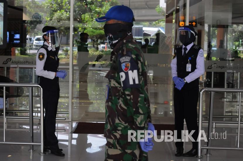 Sejumlah petugas menggunakan masker dan pelindung wajah saat berjaga di Bandara Adi Soemarmo, Boyolali, Jawa Tengah, Jumat (12/6/2020). Pemerintah membolehkan maskapai menaikkan tarif batas atas tiket pesawat agar maskapai bisa bertahan di era pandemi Covid-19.