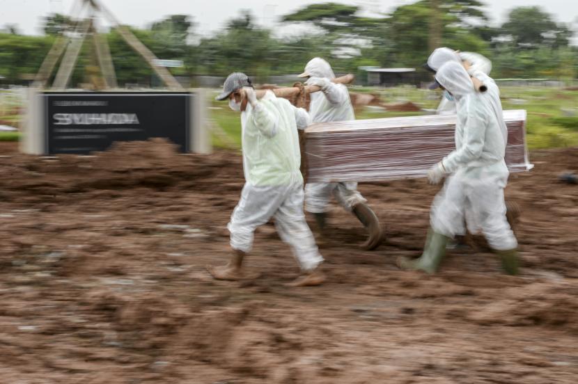 Sejumlah petugas mengusung peti jenazah pasien Covid-19 di TPU Rorotan, Jakarta.