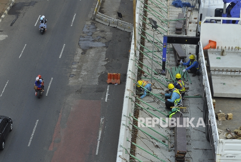 Sejumlah petugas menyelesaikan proyek pembangunan moda transportasi massal, Mass Rapid Transit (MRT) di Jalan Kyai Maja, Jakarta Selatan, Ahad (9/7).