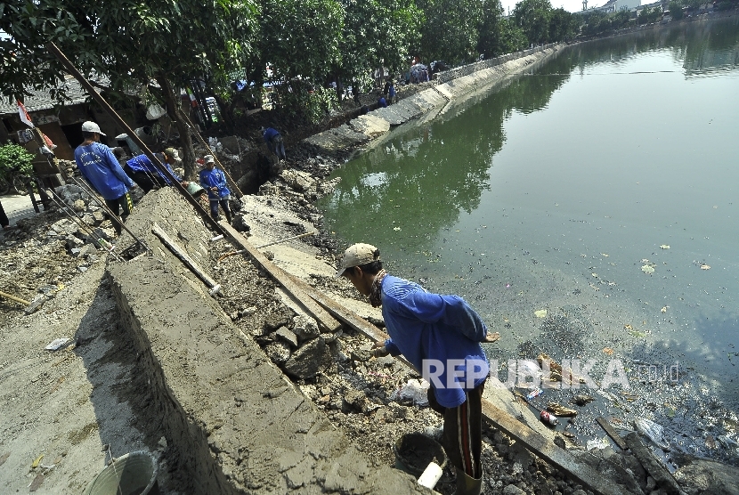  Sejumlah petugas pasukan biru menyelesaikan perbaikan tanggul Waduk Tomang Barat, Jakarta Barat.