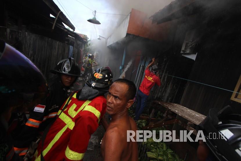 Petugas pemadam kebakaran memadamkan api yang membakar rumah di kawasan padat penduduk (Ilustrasi)