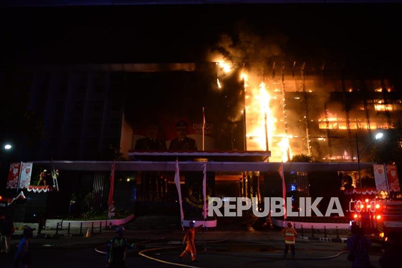 Pemadam kebakaran mencoba memadamkan api yang melalap gedung Kejaksaan Agung, Jakarta Selatan, Sabtu (22/8) malam WIB.