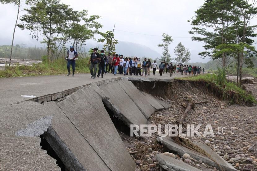 Sejumlah petugas pemerintahan daerah dan warga melintasi jalan Trans Papua terputus di Distrik Kuala Kencana, Kabupaten Mimika, Provinsi Papua, Kamis (30/7/2020). Infrastruktur masih menjadi masalah di Papua.