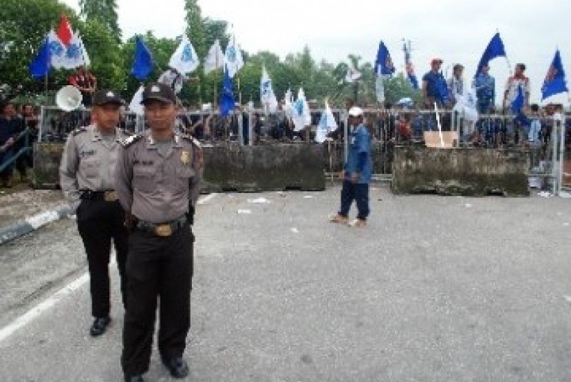 Sejumlah petugas polisi bersiaga di gerbang kamp Chevron Pasific Indonesia (CPI) yang diblokir ratusan buruh di Pekanbaru. Para buruh memblokir gerbang kamp Chevron selama dua hari untuk mendesak perbaikan kontrak yang melindungi hak-hak buruh subkontrakto