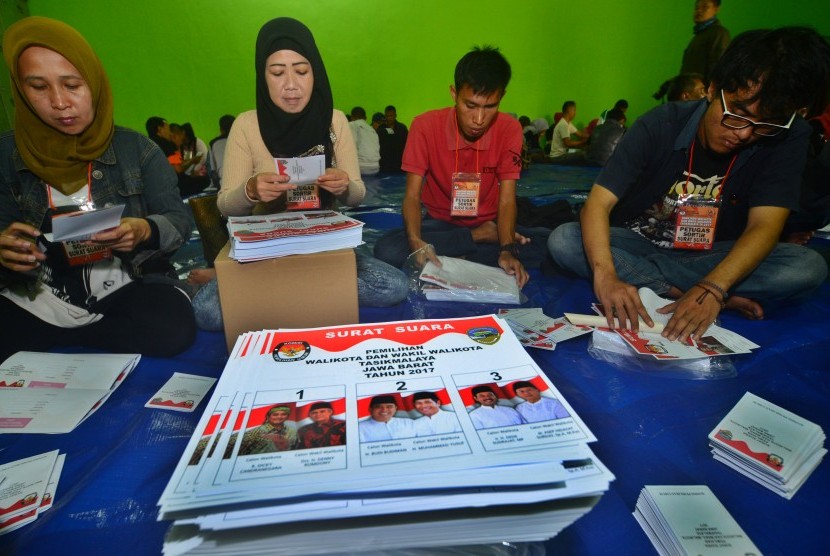 Sejumlah petugas PPK dan PPS menyelesaikan pekerjaan melipat surat suara Pilkada Serentak di Aula Gedung Graha Transisto, Kampung Cikanyere, Kota Tasikmalaya, Jawa Barat, Selasa (17/1).