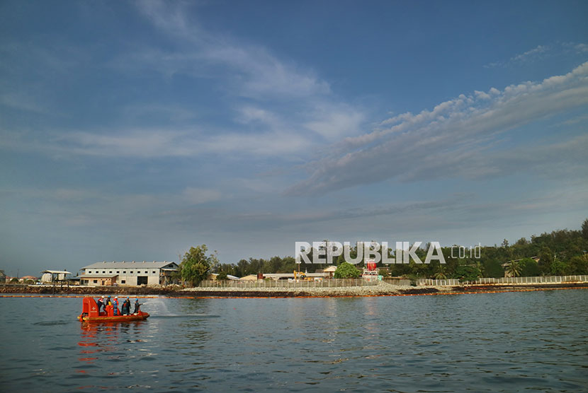 Sejumlah petugas PT Pertamina menyemprotkan cairan khusus untuk membersihkan minyak di perairan Jetty Dermaga Pelabuhan Pertamina di Balikpapan, Kalimantan Timur, Jumat (6/4). 