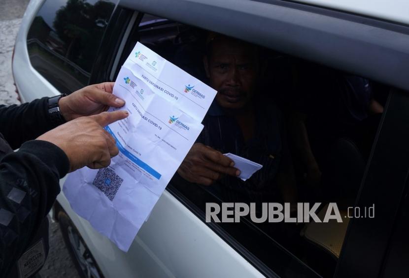 Sejumlah Petugas satgas Covid-19 melakukan pemeriksaan kartu vaksin kepada pengendara yang melintas di jalan Trans Sulawesi (ilustrasi) 