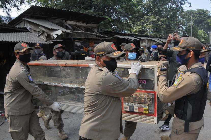 Sejumlah petugas Satuan Polisi Pamong Praja (Satpol PP) mengangkat lemari kaca saat penertiban bangunan liar di Kabupaten Bekasi.