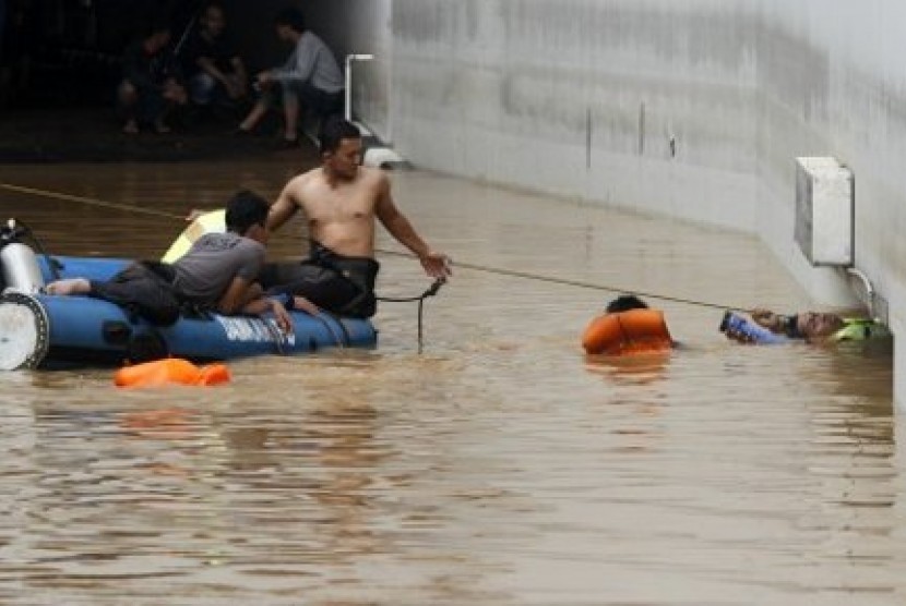 Sejumlah petugas Search And Rescue (SAR) melakukan pencarian sejumlah korban yang diduga terjebak banjir di area parkir bawah tanah (basement) yang terendam banjir di Plaza UOB, Jakarta Pusat, Jumat (18/1/2013)