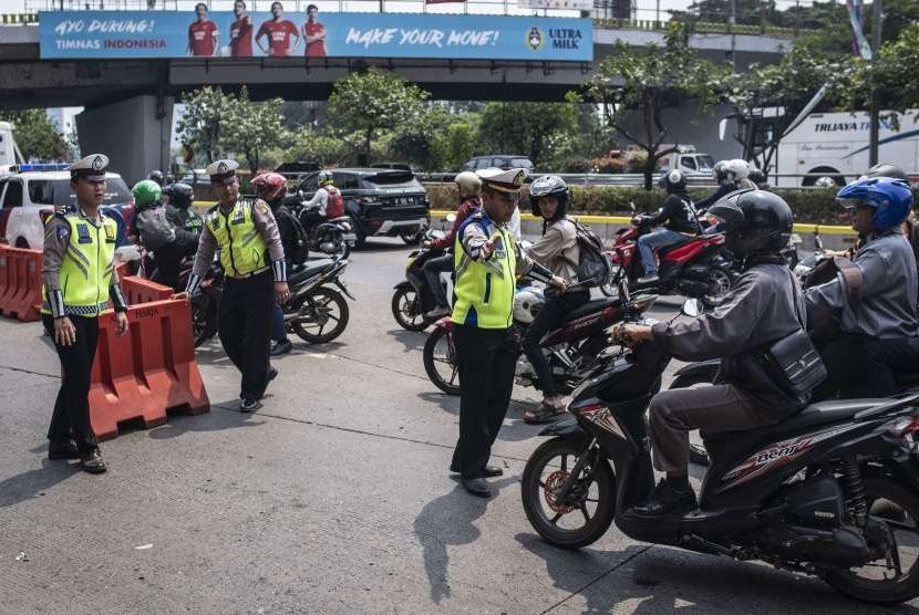 Sejumlah Polisi lalu-lintas mengatur arus lalu-lintas saat dilakukan penutupan jalan di kawasan Gelora Bung Karno (GBK), Senayan, Jakarta, Sabtu (18/8).