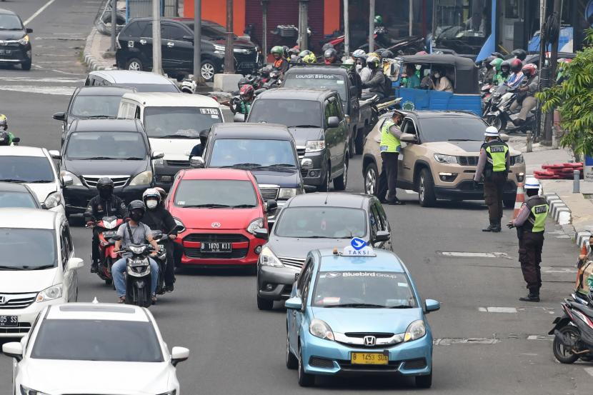Sejumlah polisi lalulintas memberhentikan pengendara mobil yang melanggar peraturan lalu lintas saat pemberlakuan aturan ganjil genap di Jalan Gajah Mada, Jakarta, Senin (6/6/2022). Polda Metro Jaya memperluas pemberlakuan sistem ganjil genap dari sebelumnya di 13 titik menjadi 26 titik untuk mengurangi kemacetan lalu lintas. 