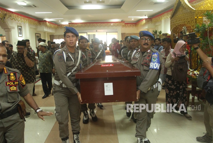Sejumlah Polisi Pamong Praja menggotong peti jenazah salah satu korban kerusuhan Wamena, yang telah tiba di Bandara International Minangkabau (BIM), Kabupaten Padang Pariaman, Sumatera Barat, Kamis (26/9/2019). 