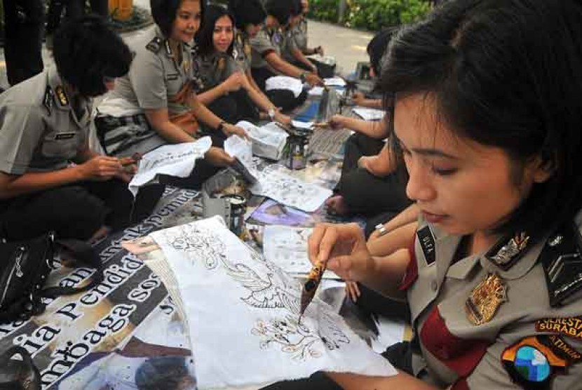  Sejumlah polisi wanita jajaran Polrestabes Surabaya, membuat batik tulis di Taman Bungkul, Surabaya, Jatim, Senin (1/10). 