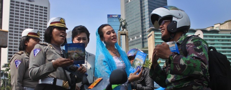 Sejumlah Polisi Wanita (Polwan) memakai Kebaya membagikan Brosur sosialisasi Undang-undang Lalu lintas kepada pengendara bermotor dalam memperingati Hari Kartini di kawasan MH. Thamrin, Jakarta, Kamis (21/4). 