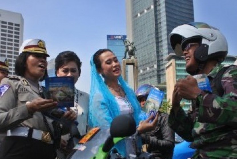 Sejumlah Polisi Wanita (Polwan) memakai Kebaya membagikan Brosur sosialisasi Undang-undang Lalu lintas kepada pengendara bermotor dalam memperingati Hari Kartini di kawasan MH. Thamrin, Jakarta, Kamis (21/4). 