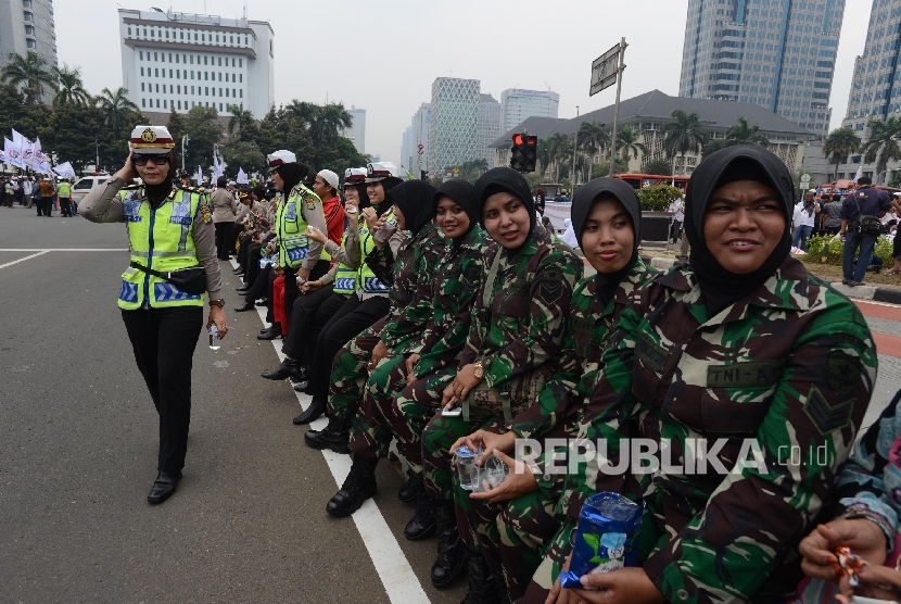  Sejumlah polwan dan Anggota TNI berhijab mengamankan Shalat Jumat saat aksi di Bundaran Patung Kuda, Jakarta, Jumat (4/11).
