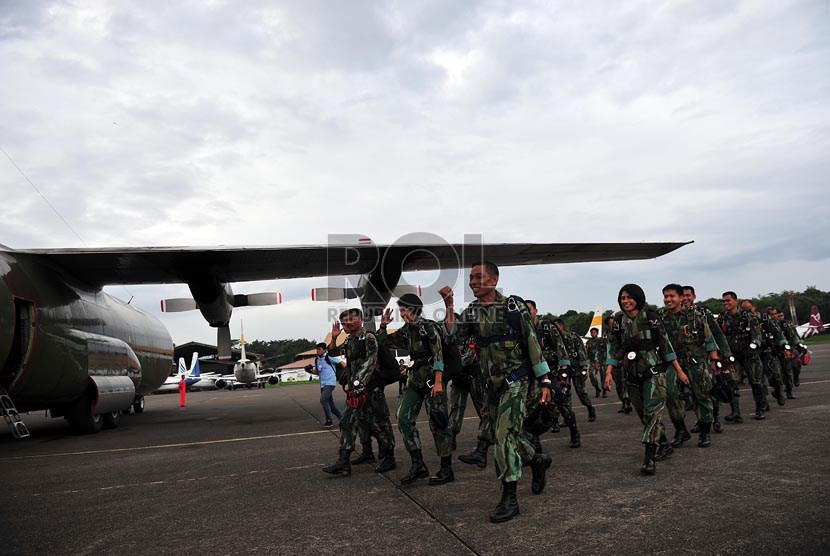   Sejumlah prajurit Korpaskhas TNI Angkatan Udara menuju pesawat Hercules untuk melakukan aksi penerjunan saat acara peringatan HUT TNI AU ke-67 di Lanud Halim Perdanakusumah, Jakarta Timur, Selasa (9/4).  (Republika/Edwin Dwi Putranto)