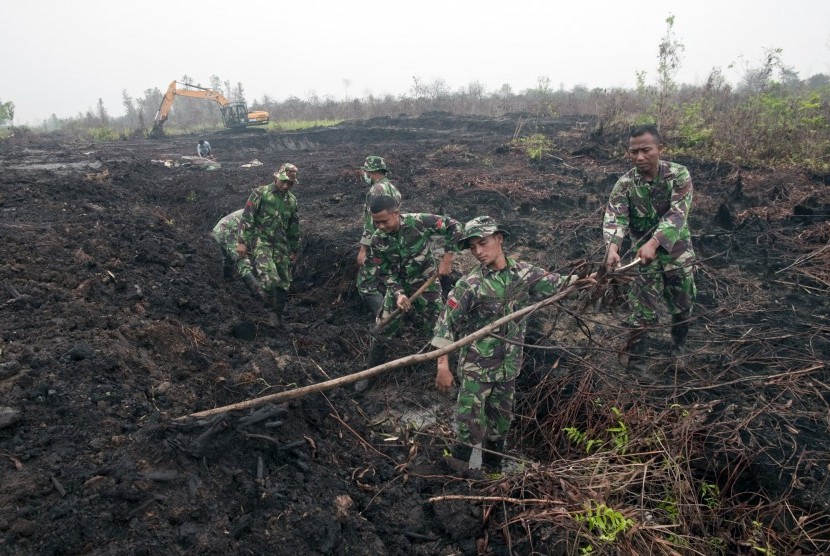  Sejumlah prajurit Kostrad menyelesaikan pembuatan embung penampung air di lahan gambut bekas kebakaran di Desa Rimbo Panjang Kabupaten Kampar, Riau, Jumat (9/10).