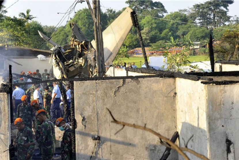  Sejumlah prajurit TNI AU berada di dekat bangkai Pesawat Fokker 27 yang jatuh di sekitar kompleks perumahan Halim Perdanakusuma, Jakarta, Kamis (21/6). 