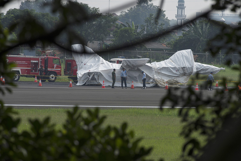 Sejumlah prajurit TNI AU berjaga di dekat badan pesawat tempur F16 yang ditutupi terpal di ujung landasan pacu Pangkalan Udara Halim Perdanakusuma, Jakarta Timur, Kamis (16/4).  (ANTARA/Widodo S. Jusuf).