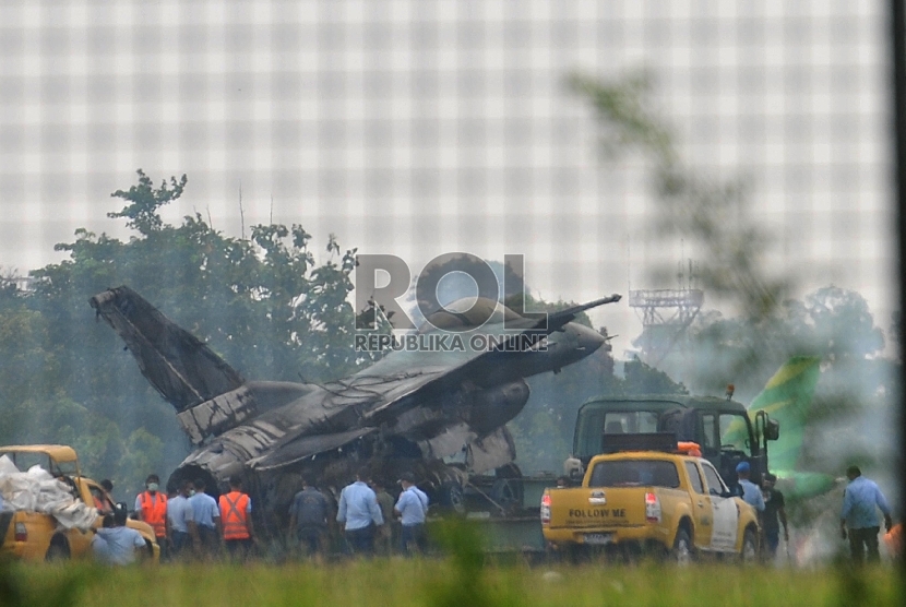 Sejumlah prajurit TNI AU melakukan proses evakuasi badan pesawat tempur F16 yang terbakar di ujung landasan pacu Pangkalan Udara Halim Perdanakusuma, Jakarta Timur, Kamis (16/4). (Republika/Edwin Dwi Putranto)