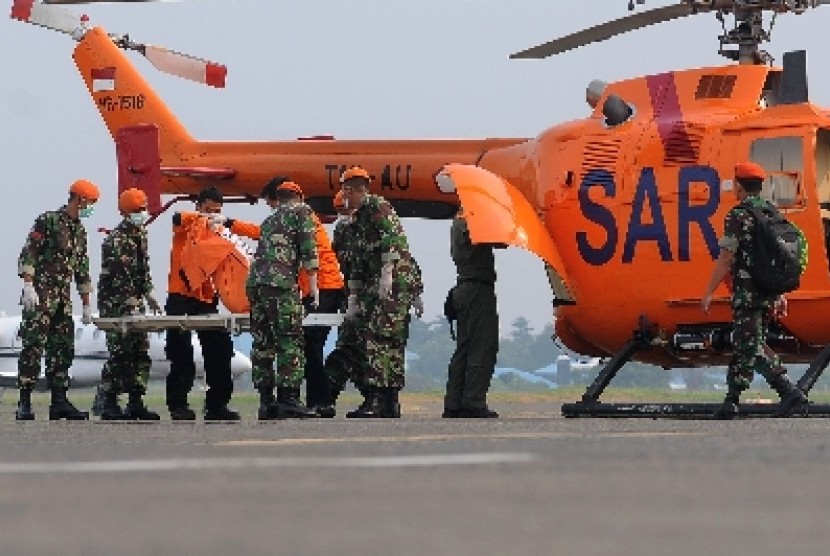Sejumlah prajurit TNI AU, personil Basarnas dan PMI mengangkat kantong jenazah korban kecelakaan pesawat Sukhoi Super Jet 100 di Bandara Halim Perdanakusuma, Jakarta, Sabtu (12/5). 