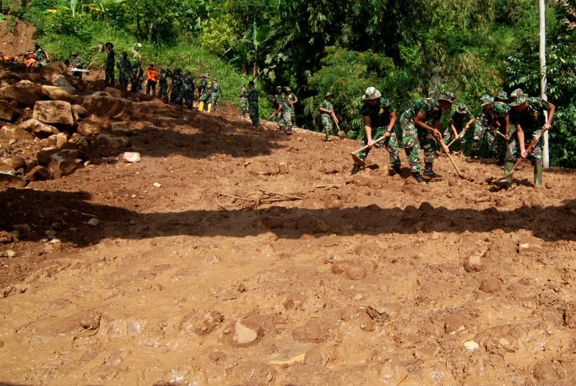 Sejumlah prajurit TNI bergotong royong membersihkan material tanah longsor yang menutup akses jalan di Desa Sepakung, Banyubiru, Kabupaten Semarang, Jawa Tengah, Kamis (20/10). 