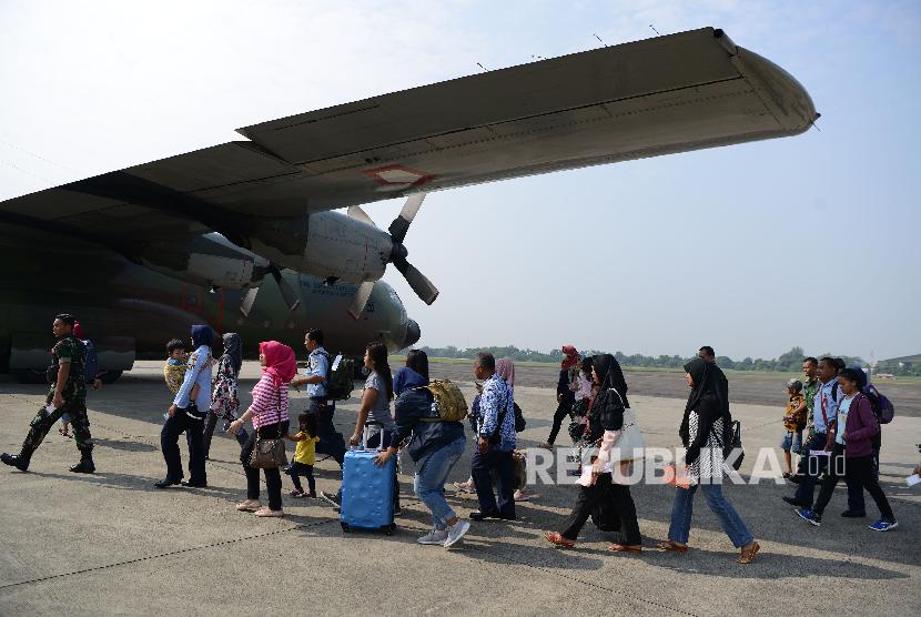 Sejumlah prajurit TNI dan keluarga berjalan menuju pesawat Hercules sesaat sebelum lepas landas di Lanud Halim Perdanakusuma, Jakarta Timur, Sabtu (1/6).