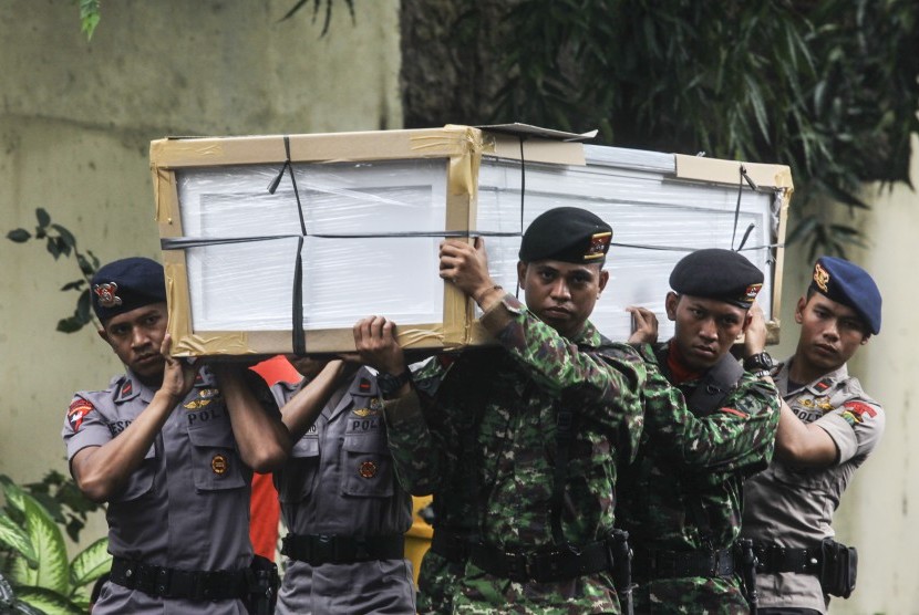 Sejumlah prajurit TNI dan Polri mengangkat peti Jenazah di RS Polri, Jakarta, Senin (21/3). Sebanyak 13 peti jenazah tersebut akan digunakan untuk menyemayamkan jenazah korban kecelakaan helikopter BELL 412 nomor HA 5171 milik TNI di Desa Kasiguncu, Poso P