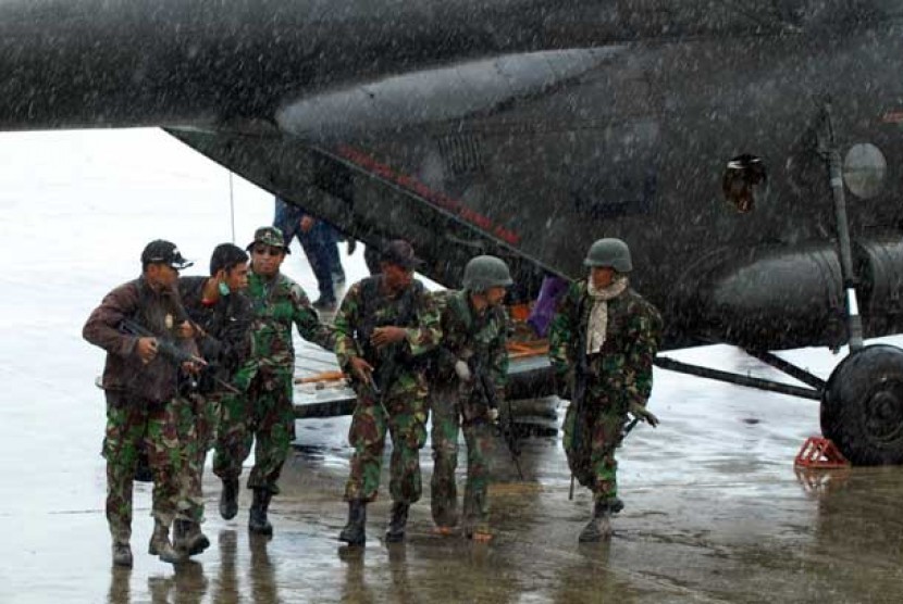 Sejumlah prajurit TNI memapah rekan mereka yang menjadi korban penembakan dan penyergapan kelompok sipil bersenjata setibanya di Bandara Sentani, Kabupaten Jayapura, Papua, Ahad (24/2).